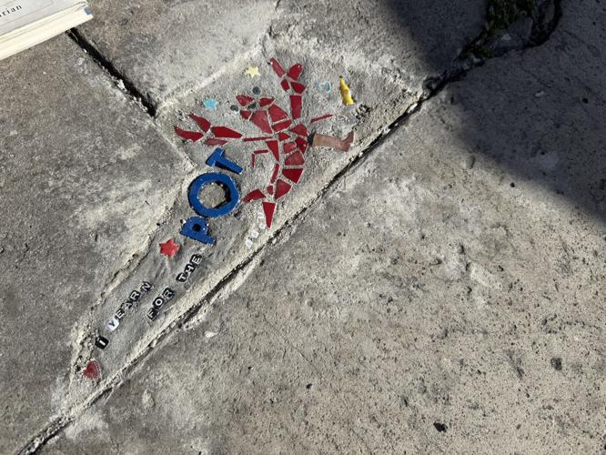 A photo of a pothole filled with a mosaic of a lobster and the message 'I yearn for the pot'. Photo by Kasey Bubnash of NOLA.com